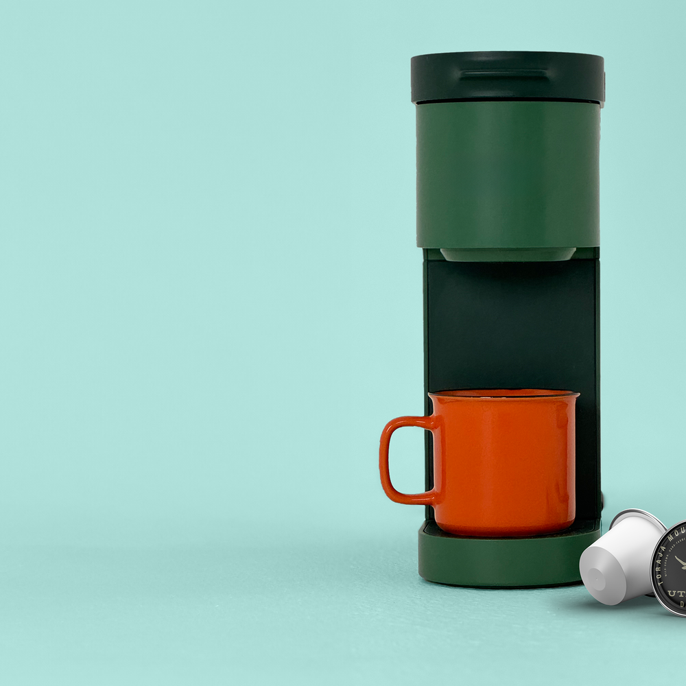 keurig machine with cup of coffee and toraja mountain coffee kcups