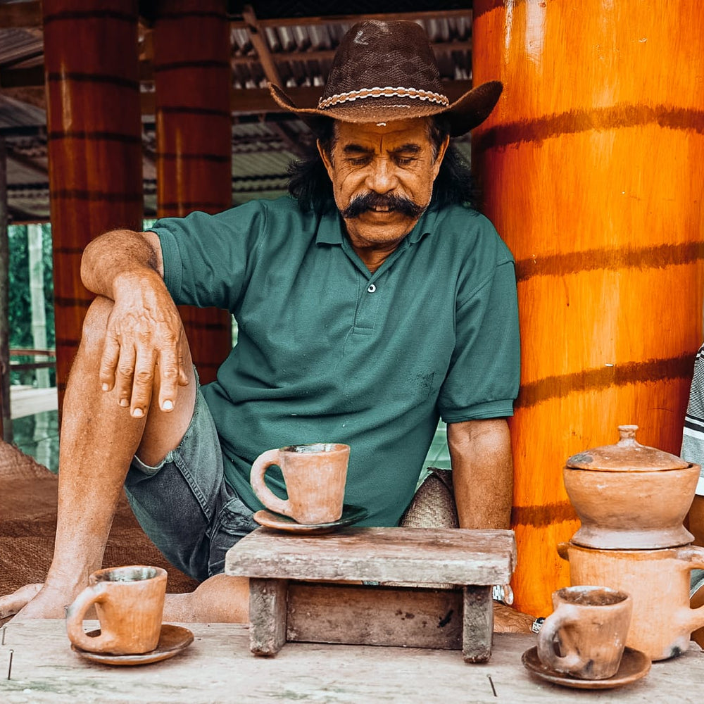 Torajan villagers drinking coffee from traditional clay earthenware