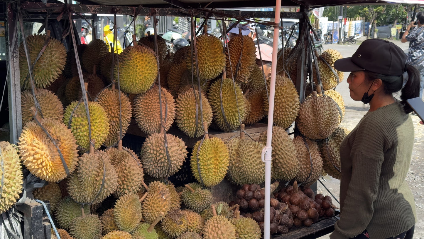 female vendor selling durian fruit in Bali